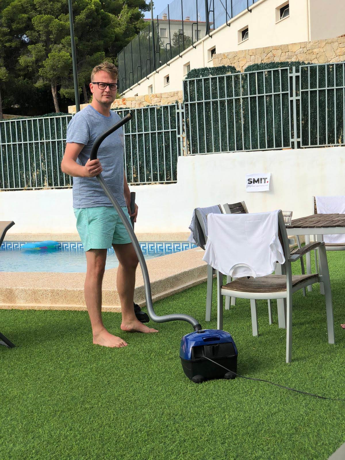 Pieter poserend met een stofzuiger in plaats van met een gieter